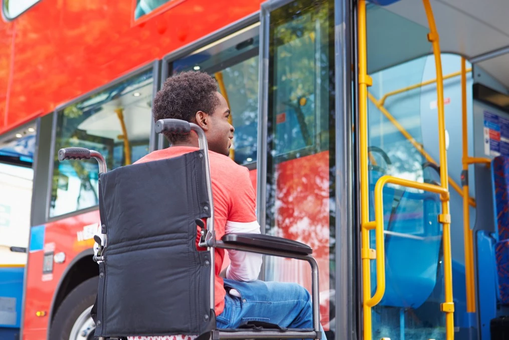 Man in wheelchair waiting to get on bus